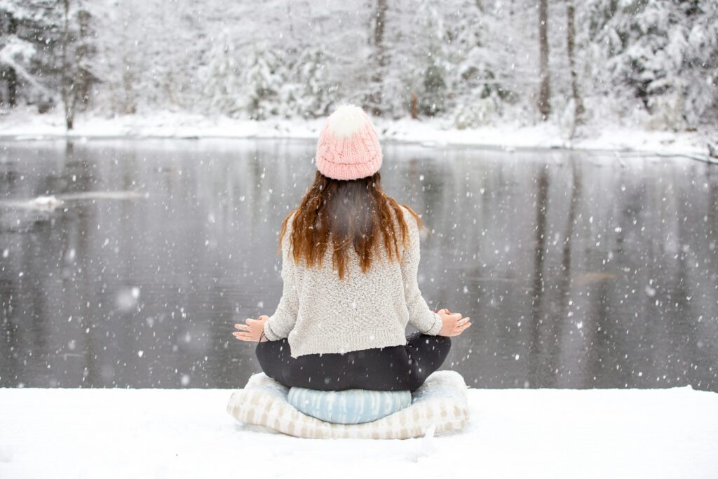 A serene winter meditation by a tranquil snowy lake in New Hampshire.